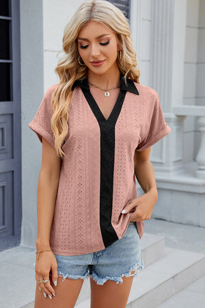 Blush pink perforated polo top with black contrast V-neck and short sleeves