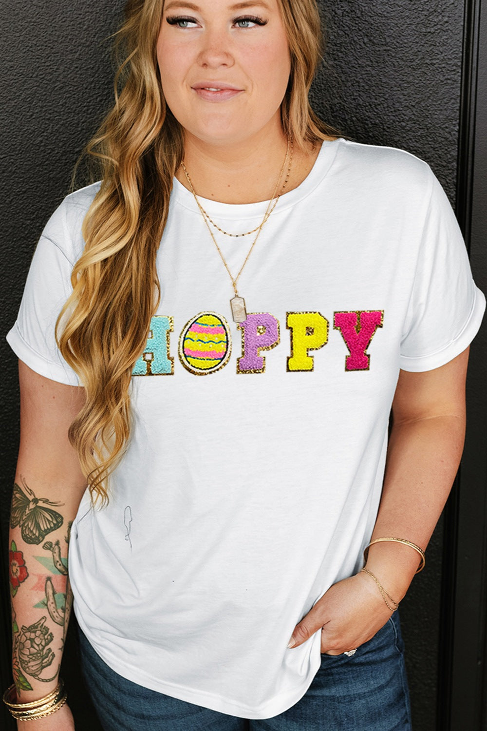 White t-shirt with sequin "Hoppy" graphic featuring an Easter egg.