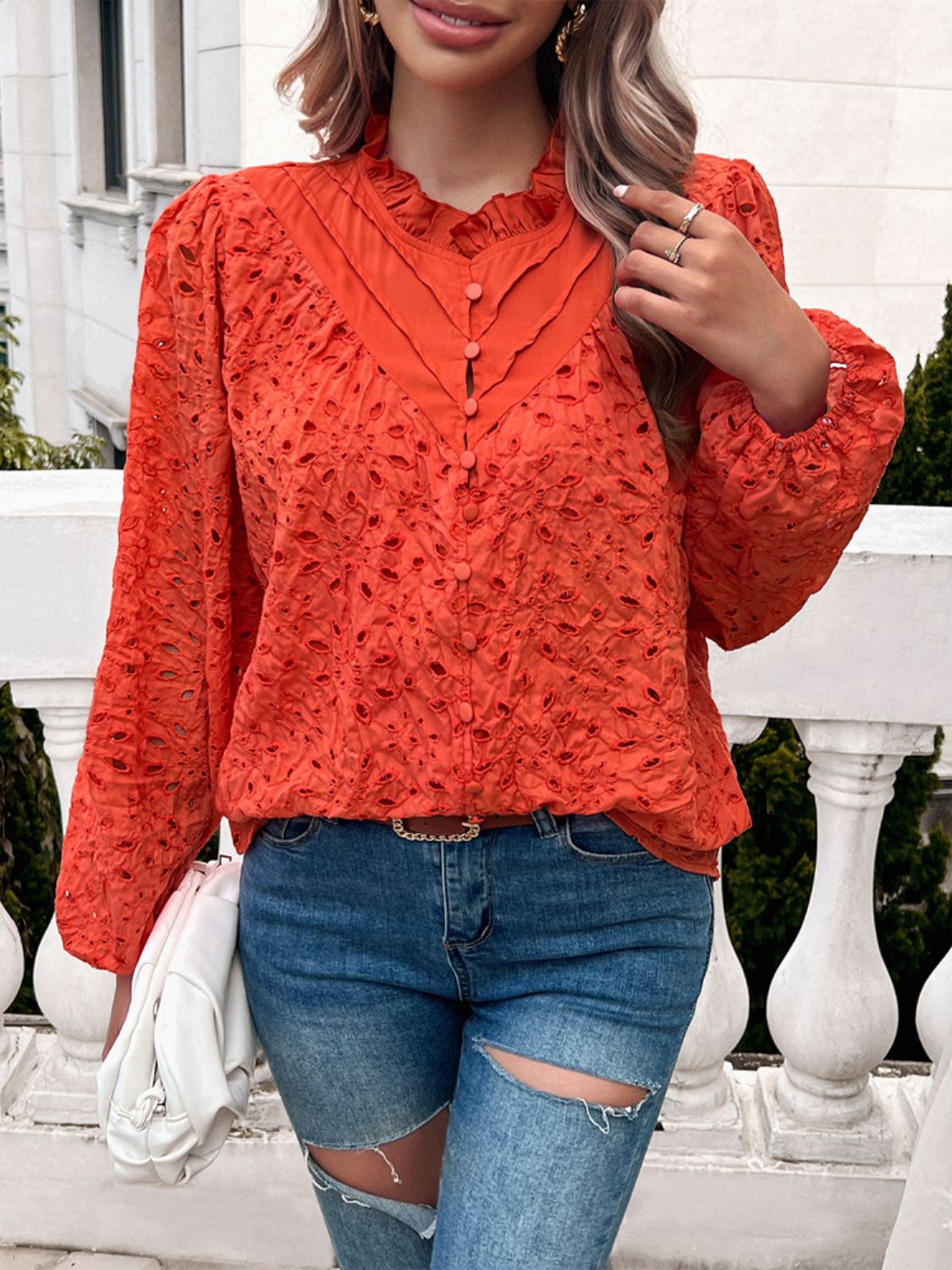 Orange-red eyelet embroidered blouse with ruffle collar and button front.