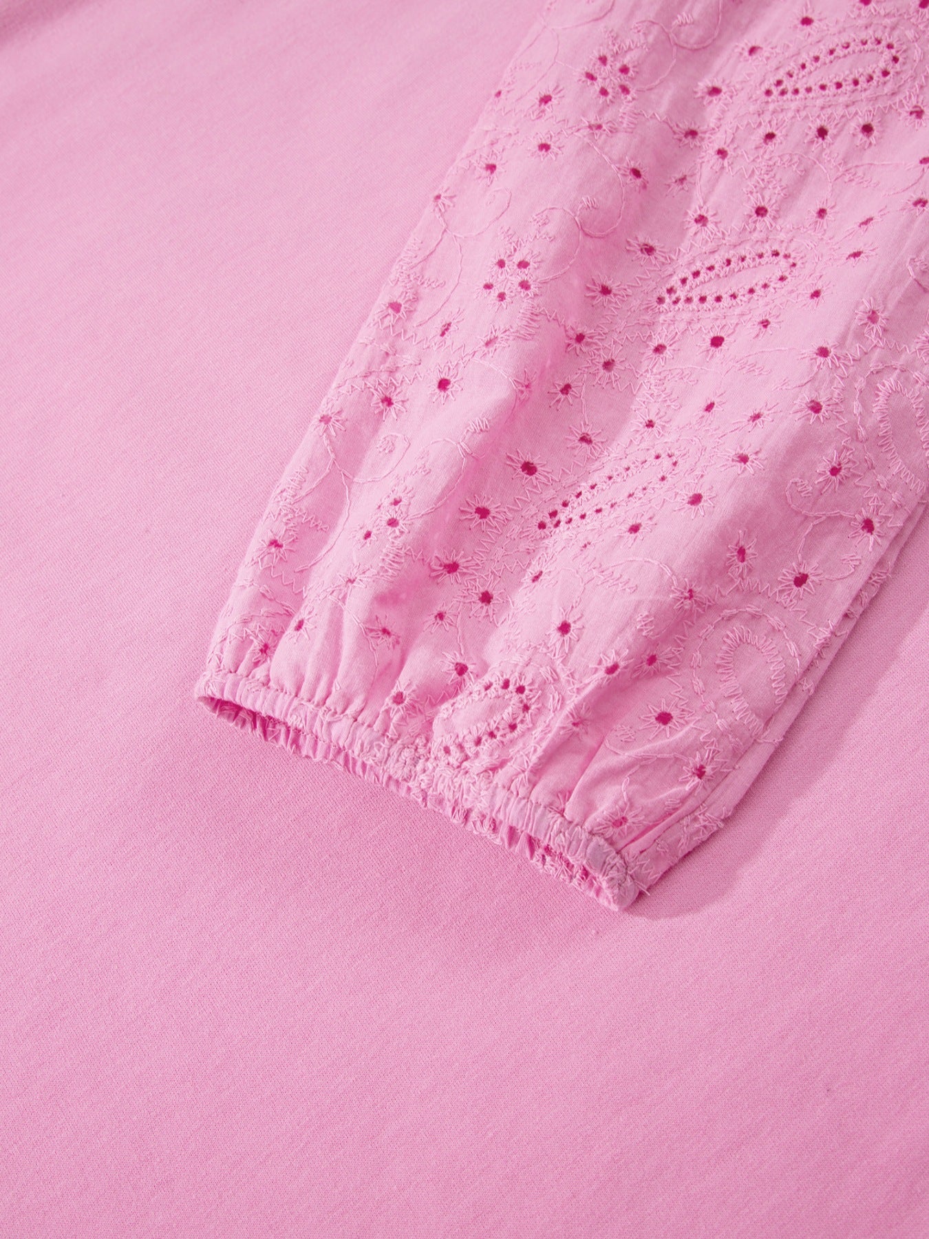 Pink cotton crew-neck sweatshirt with embroidered eyelet detail on the sleeve cuff.