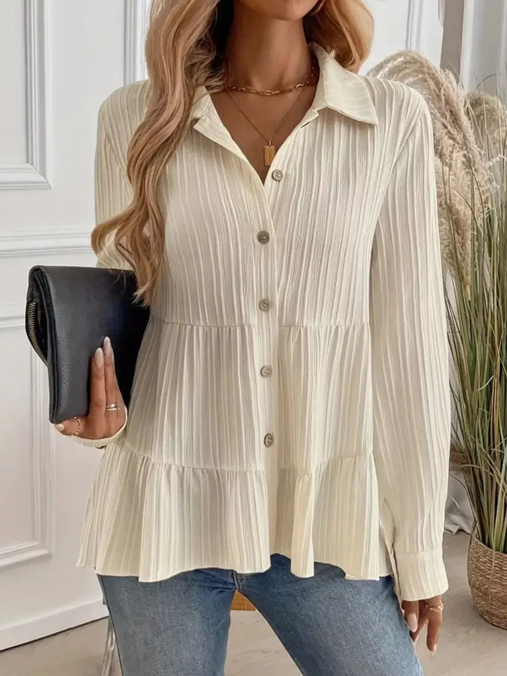 Cream textured tiered button-down shirt with crinkled fabric and button details.