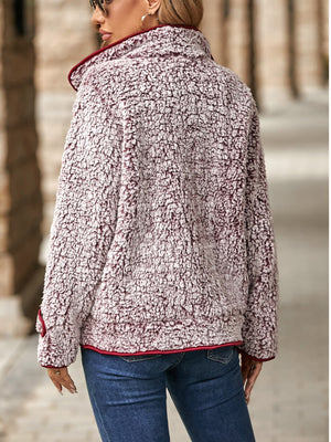 Sherpa jacket in burgundy with crimson piping and a fuzzy texture.