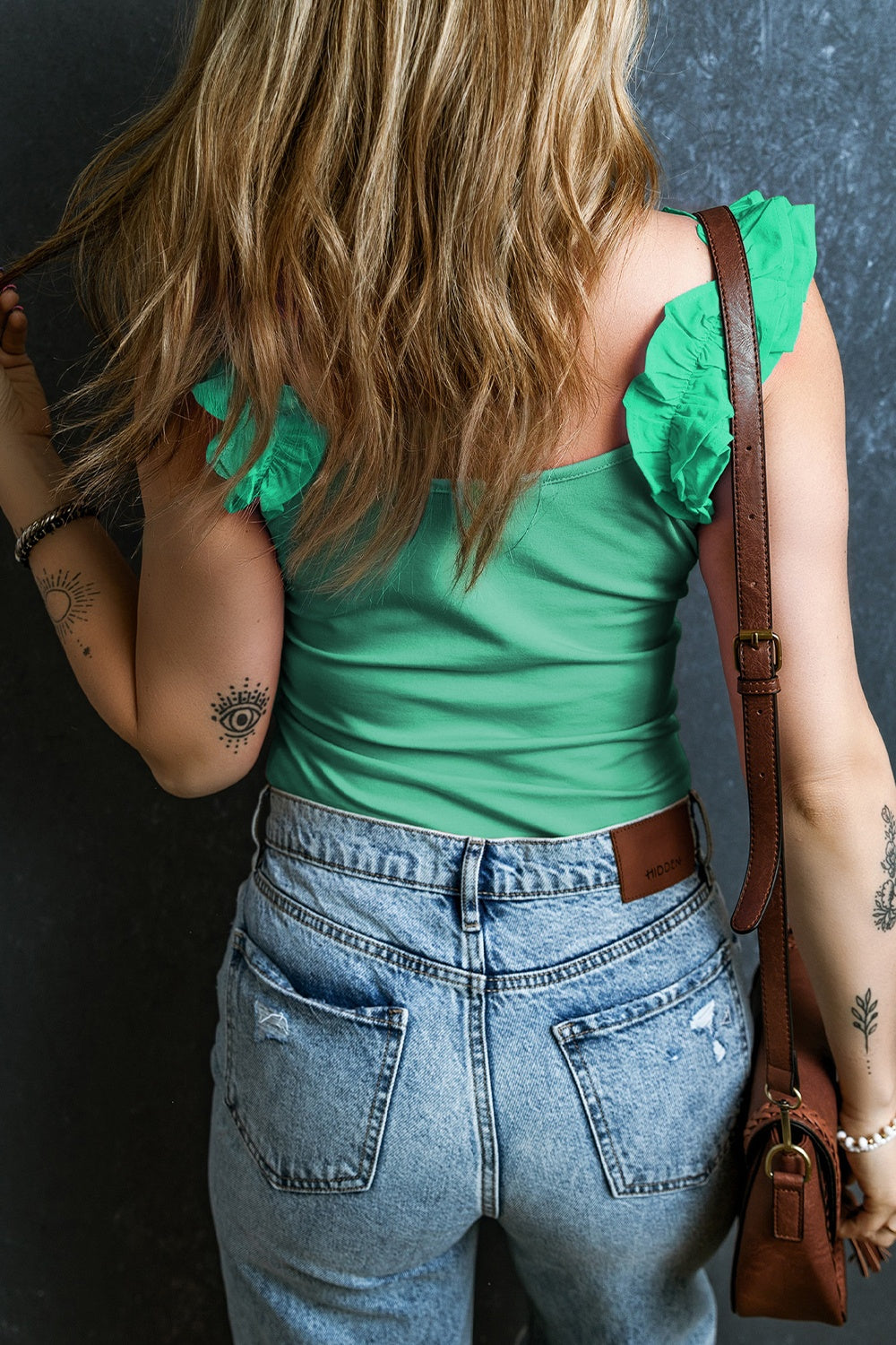 Light green ribbed tank top with ruffled straps, styled with denim jeans.