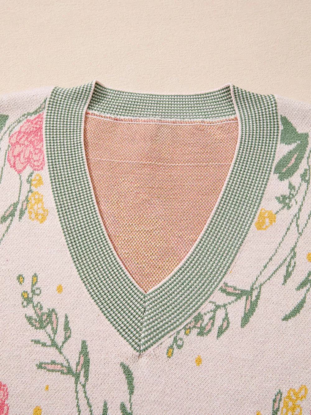 Floral V-neck knit sweater with green trim and relaxed fit.