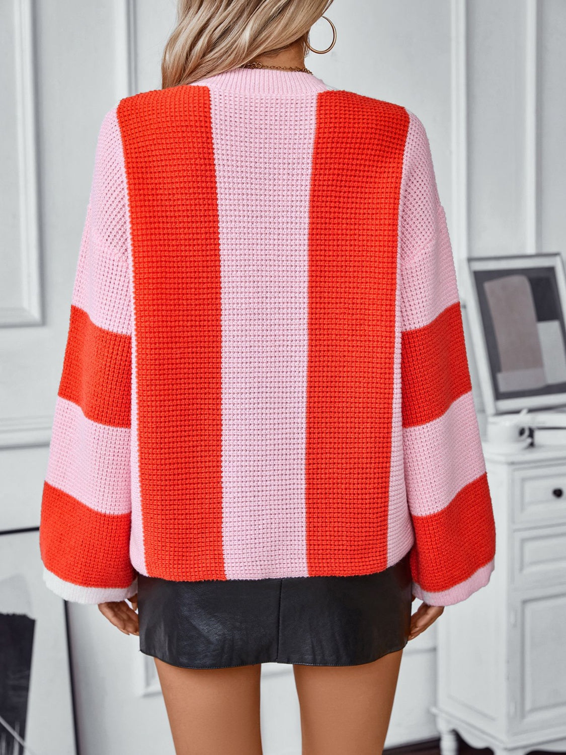 Colorblock stripe knit sweater in pink and orange with a waffle knit texture and long sleeves.