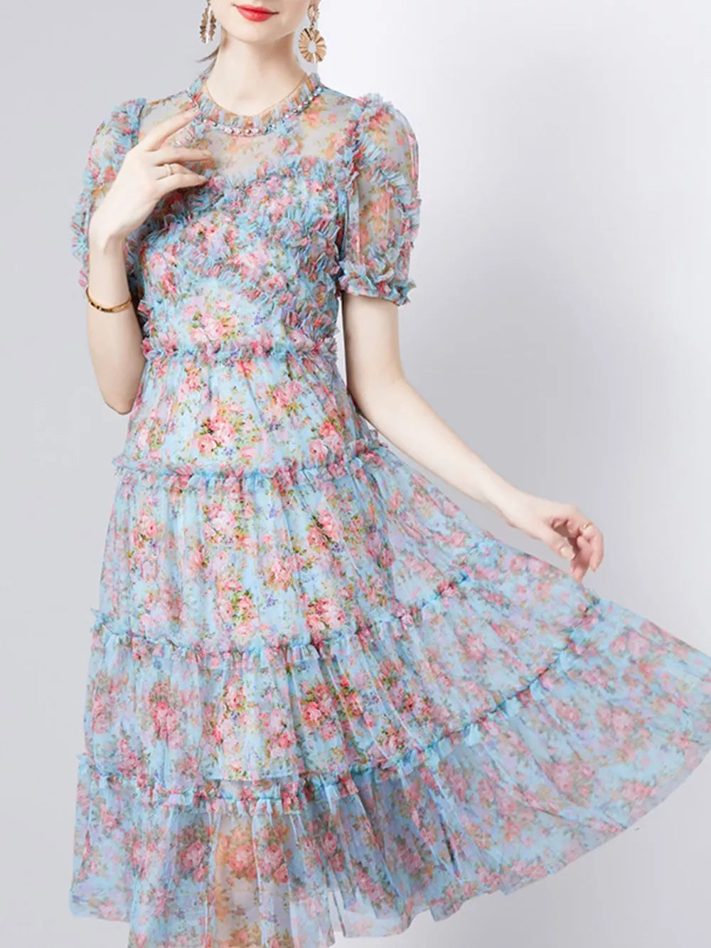 Light blue floral print tiered midi dress with ruffled details and short sleeves.