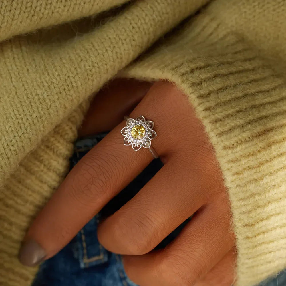 Silver ring with floral filigree and yellow zirconia center stone.