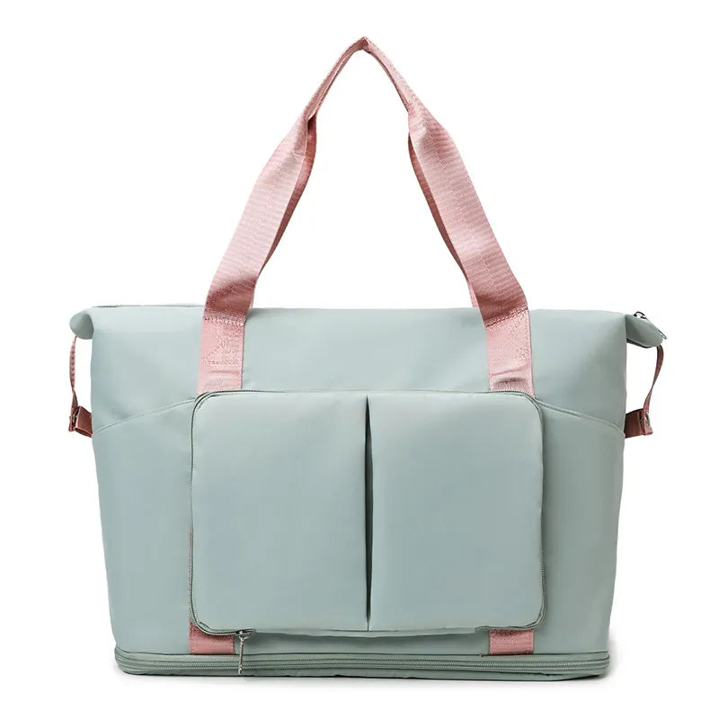 Sage green foldable travel tote with pink straps and two exterior pockets.