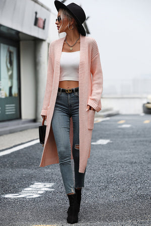 Longline knit cardigan in watermelon pink with pockets, acrylic material, open front.