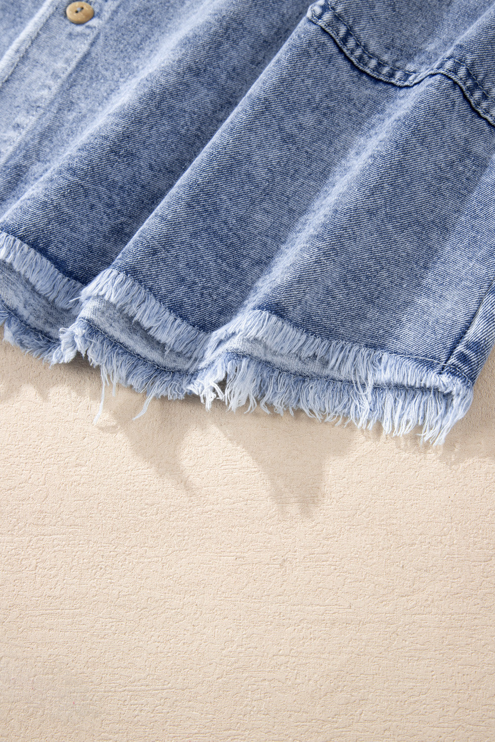 Acid wash denim shirtdress in medium with raw hem detail and button closure.