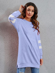 Varsity stripe raglan sweatshirt dress in blue purple with white sleeve stripes, crew neck, long sleeves, and side slits.
