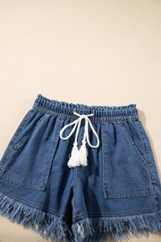 Navy denim drawstring shorts with frayed hem and white tassel detail.