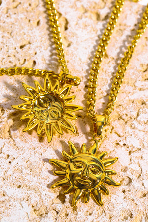 Gold sunburst pendant necklace with curb chain.