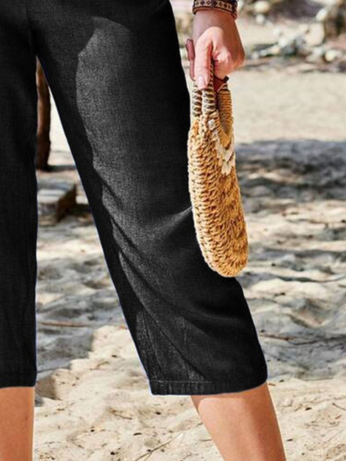 Black cropped denim trousers with elastic waist and a relaxed fit.