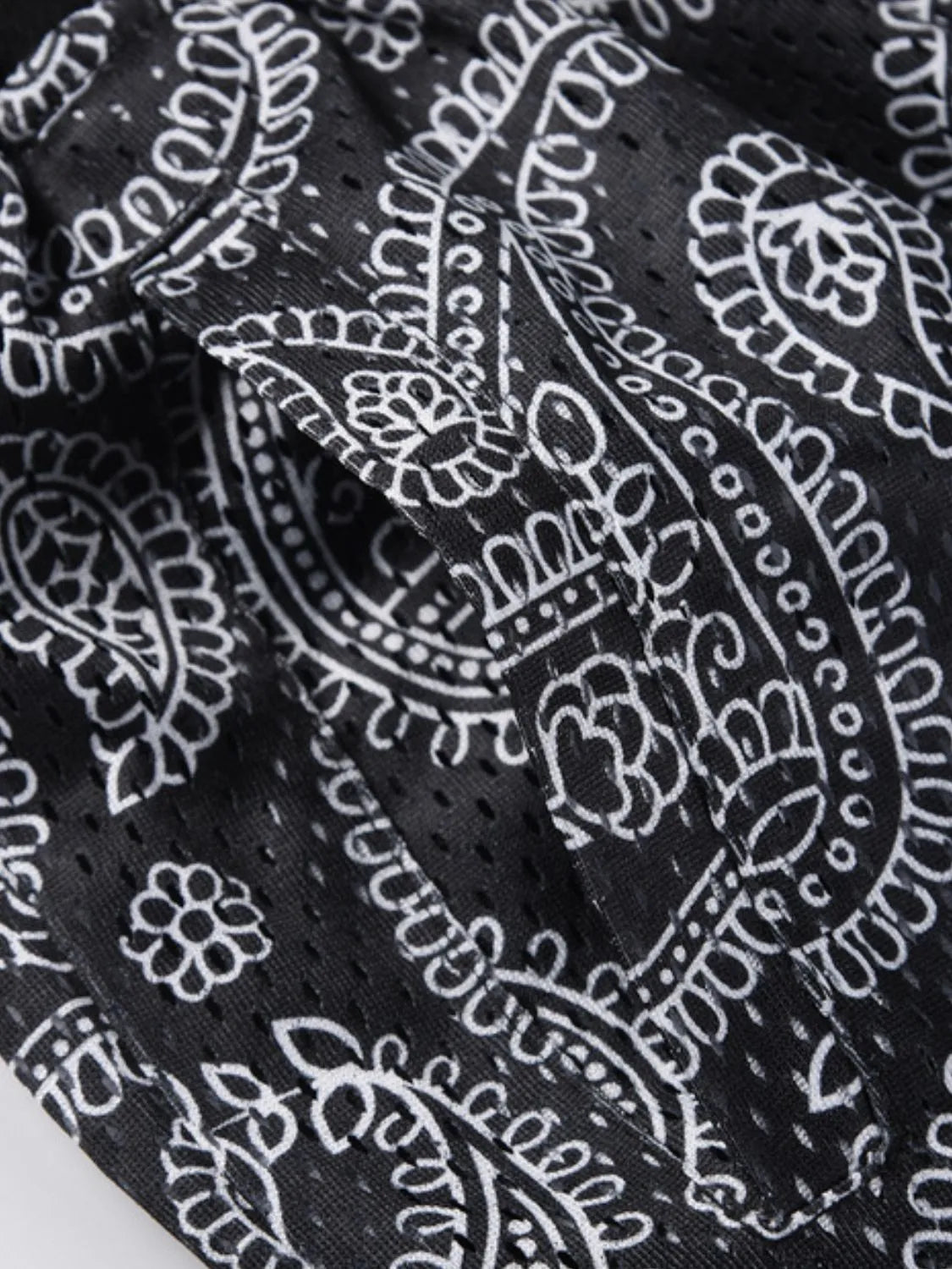Black paisley mesh basketball shorts with a pocket detail.