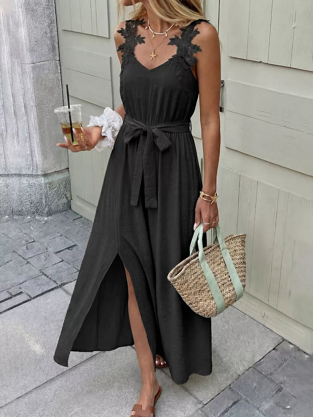 Black lace-trimmed maxi dress with V-neck, sleeveless, belted waist, and high slit.