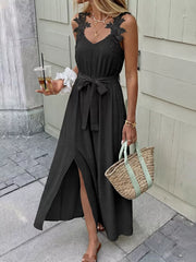 Black lace-trimmed maxi dress with V-neck, sleeveless, belted waist, and high slit.