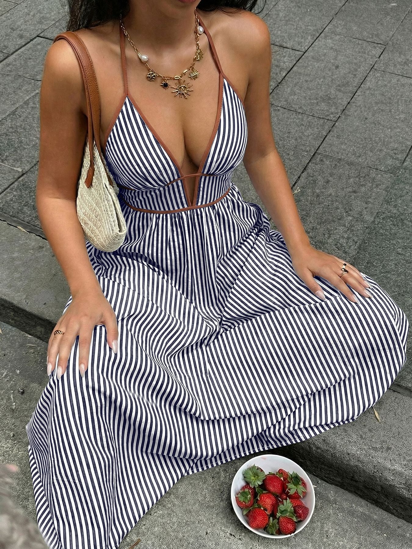 Striped maxi dress with halter neckline and deep v, featuring brown trim.