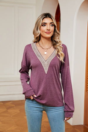 Relaxed knit sweater in lilac with lace-trimmed V-neck and long sleeves.