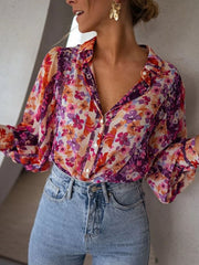 Women's vibrant floral print button-up shirt with a V-neck and long sleeves.