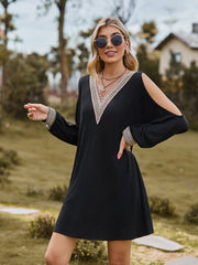 Black cold shoulder mini dress with lace trim V-neck and cuffs.