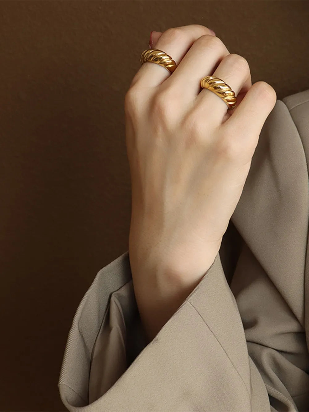 Gold sculpted steel croissant ring with twisted band detail.