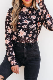 Black sheer floral mock neck blouse with long sleeves.