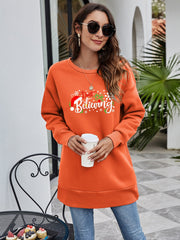 Orange graphic tunic sweatshirt with "Don't Stop Believing" holiday text and Santa hat graphic.