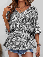 Black and white abstract print cinched waist blouse with V-neck and short sleeves.