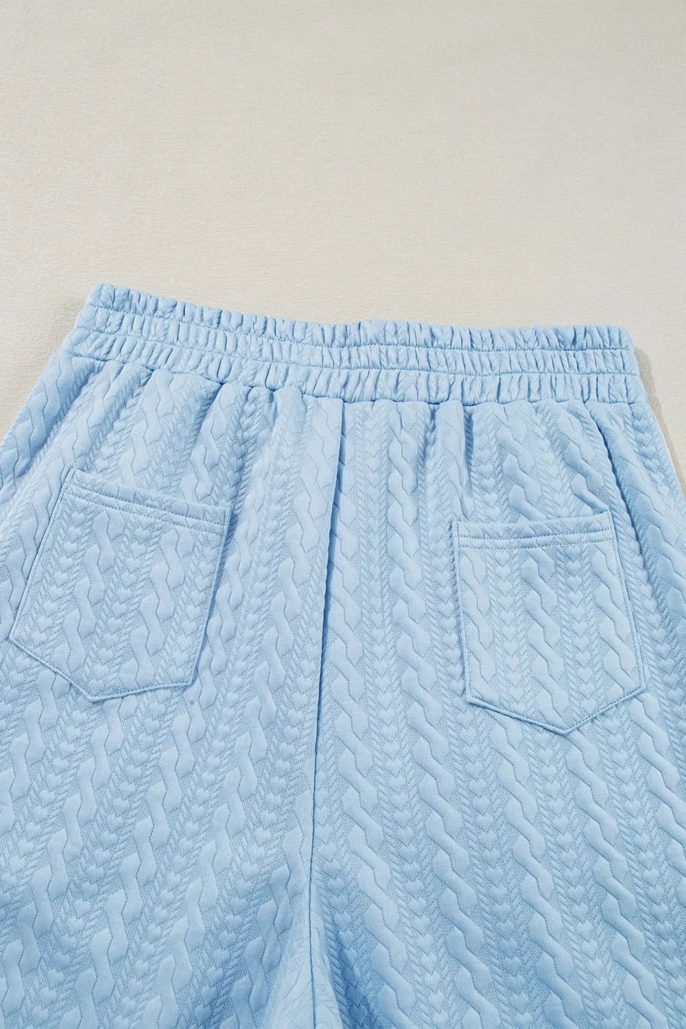 Light blue cable knit lounge shorts with elastic waist and two back pockets.