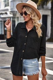 Black waffle-knit oversized shirt jacket with button front and chest pocket.