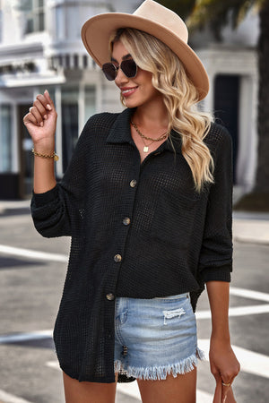 Black waffle-knit oversized shirt jacket with button front and chest pocket.