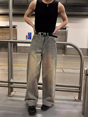 Vintage wash wide-leg jeans with distressed details and paint splatters.