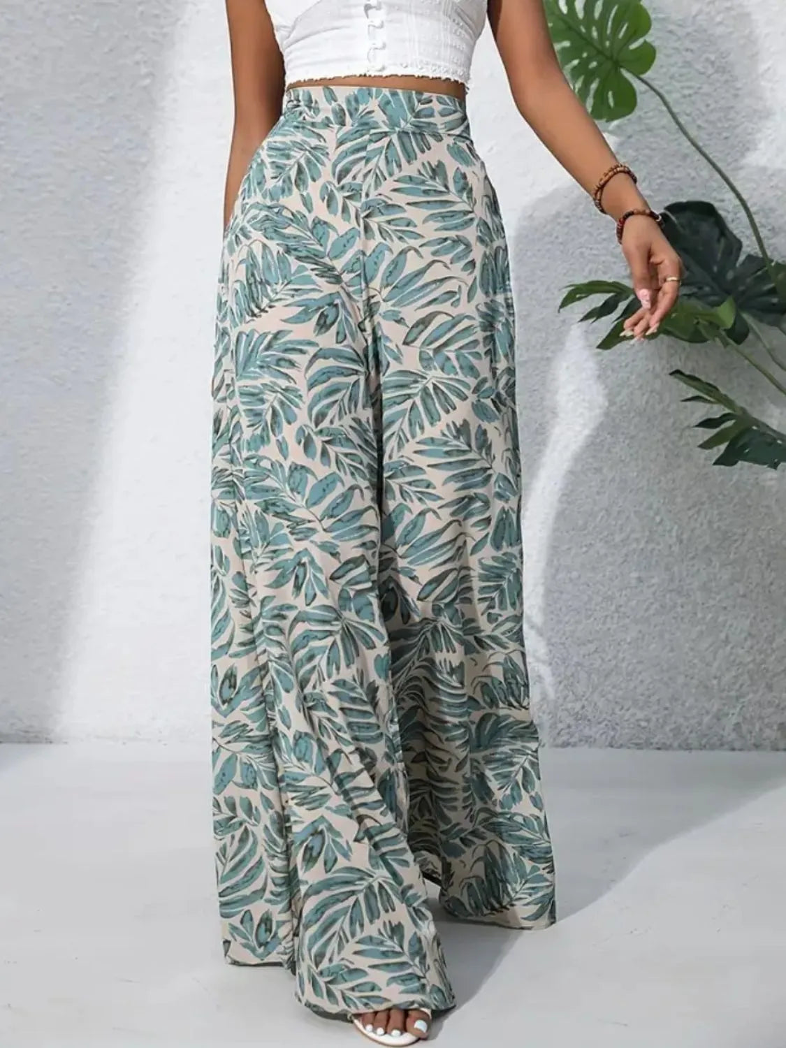 Palazzo trousers in 100% polyester with a tropical leaf print in green and beige.