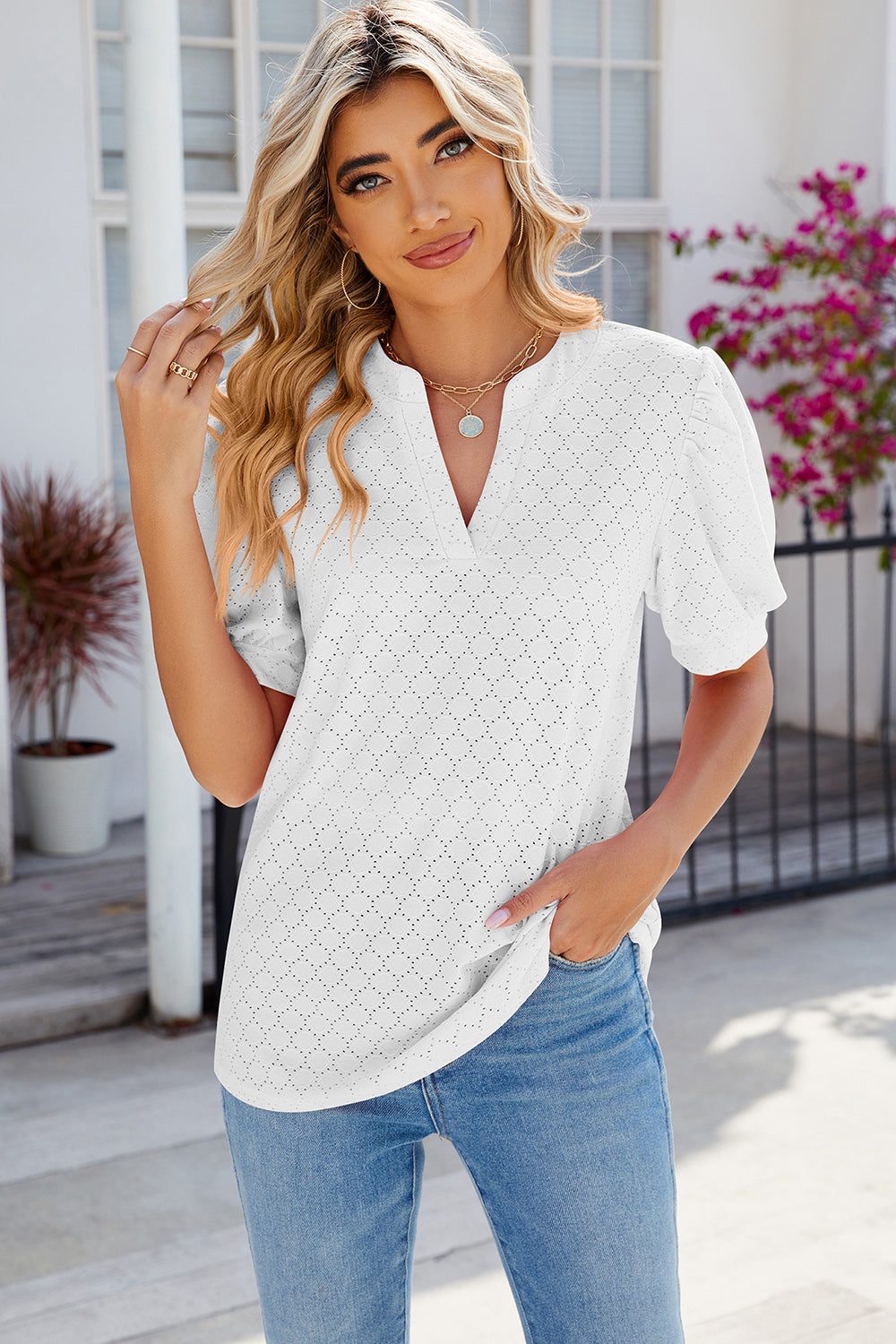 White eyelet V-neck blouse with puff sleeves and diamond pattern.