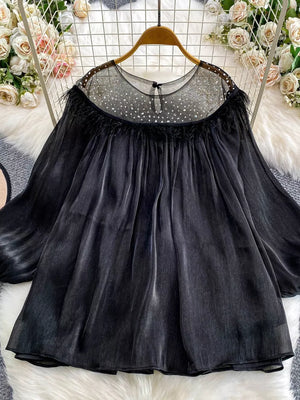 Black sheer blouse with rhinestone embellishments and feather trim.