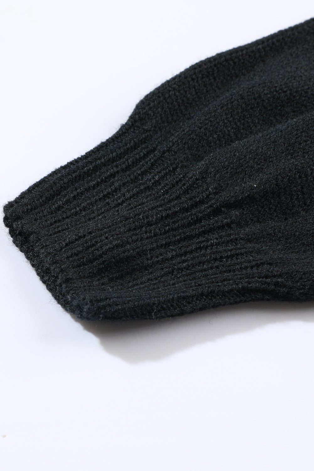 Black acrylic knit cardigan sleeve detail with ribbed cuff