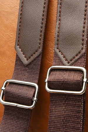 Caramel leather convertible backpack straps with adjustable metal buckles and brown stitching.