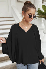 Black voluminous sleeve blouse with keyhole neckline and tie detail.
