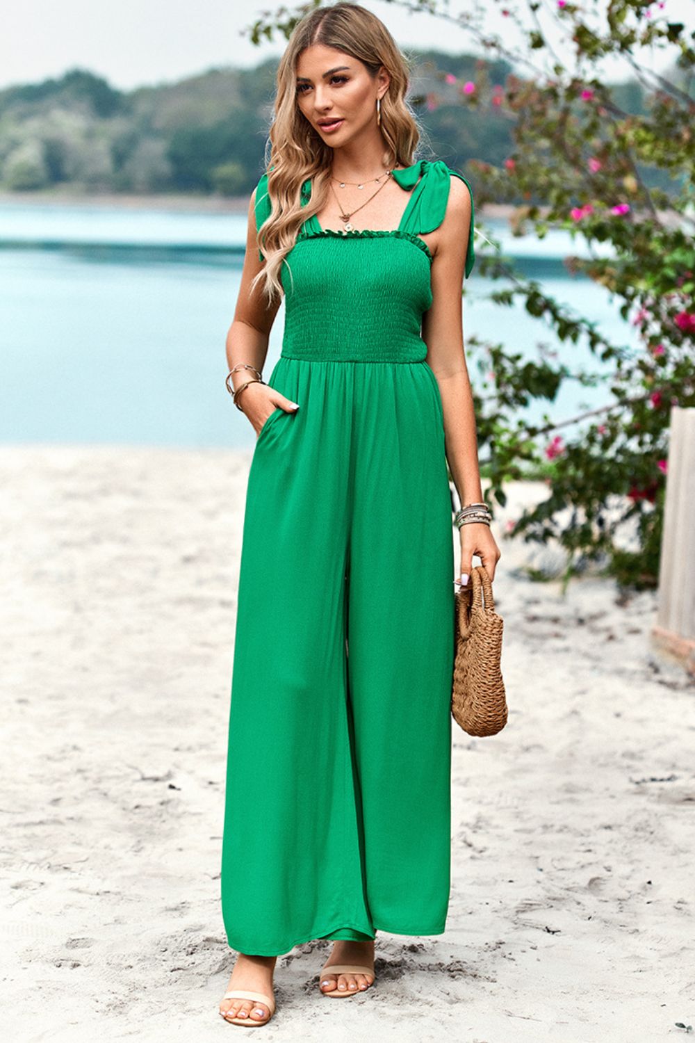 Green smocked bodice tie-strap palazzo jumpsuit with wide legs and pockets.