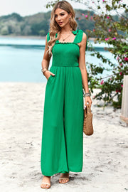 Green smocked bodice tie-strap palazzo jumpsuit with wide legs and pockets.