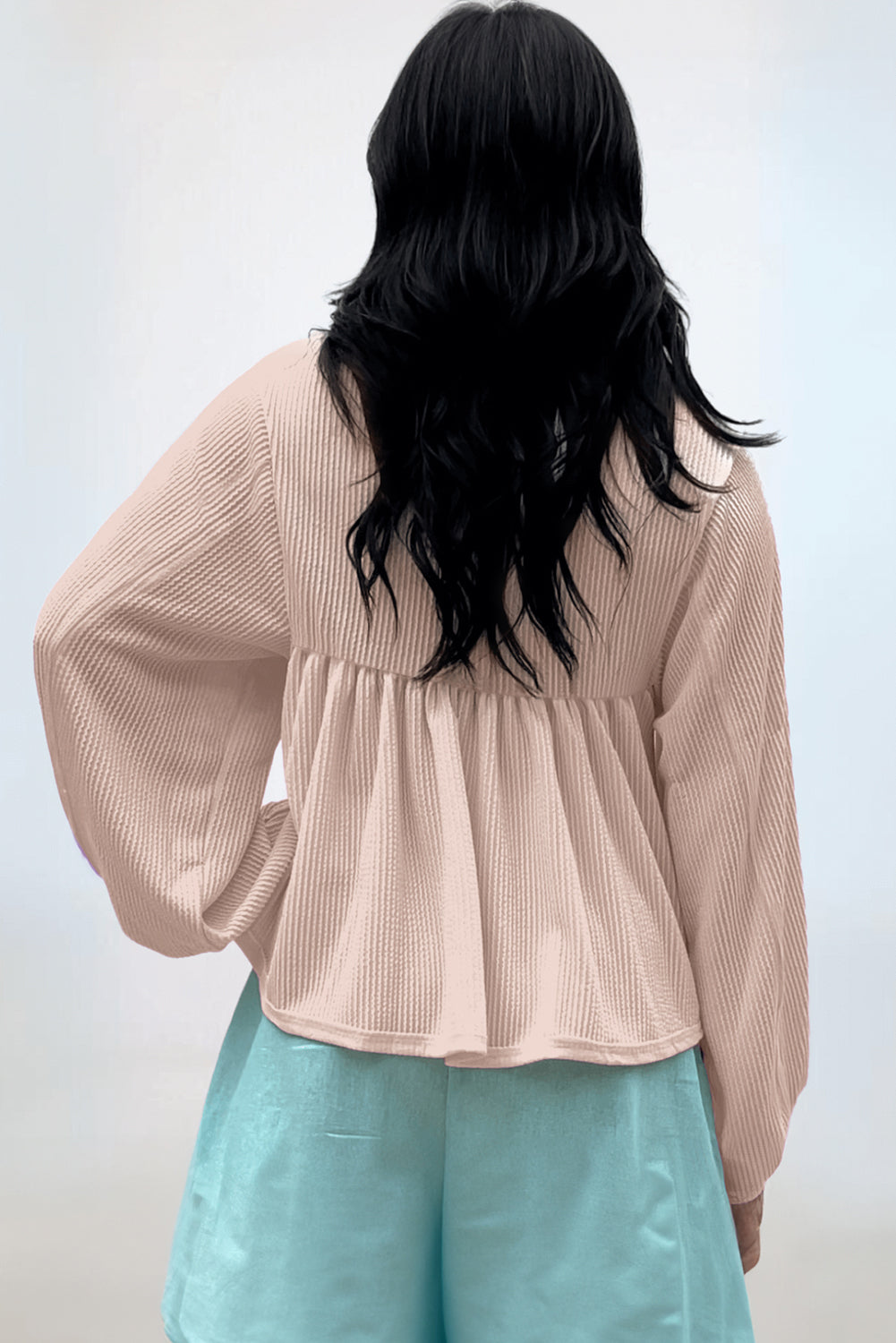 Beige textured blouse with gathered yoke and balloon sleeves.