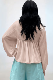 Beige textured blouse with gathered yoke and balloon sleeves.