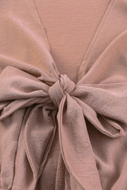 Tie-front blouson sleeve playsuit in Dusty Pink with a knotted V-neck detail.