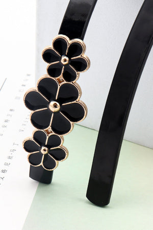 Black skinny belt with gold trim and black floral blossom embellishments.
