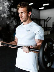 White performance fit raglan sleeve tee with subtle geometric pattern and logo detail