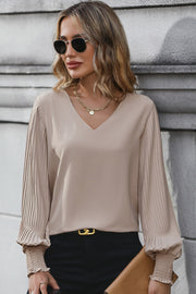 Mocha V-neck blouse with pleated long sleeves and smocked cuffs.