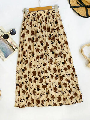 Botanical pleated midi skirt in tan with a floral print, crinkled fabric, and elastic waist.