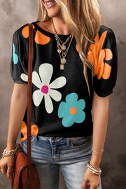 Black puff sleeve top with large white, blue, and orange floral print.