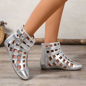 Silver ankle cutout boots with buckles and adjustable strap detail.